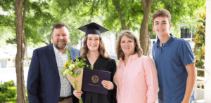 Girl student takes photo with family at graduation